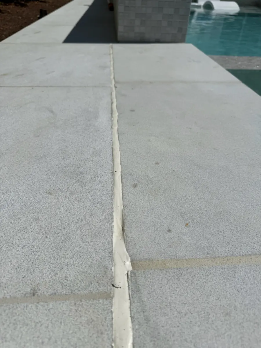 Deteriorated pool deck expansion joint before resealing in Newport Beach, CA